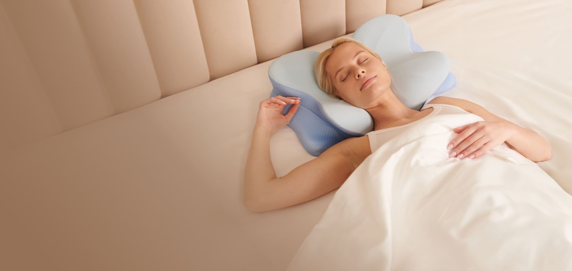 Woman sleeping peacefully on the Derila Ergo pillow in a comfortable bed